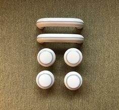 four white plastic knobs and covers on a carpet