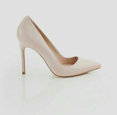 a woman's nude high heeled shoe on a white surface