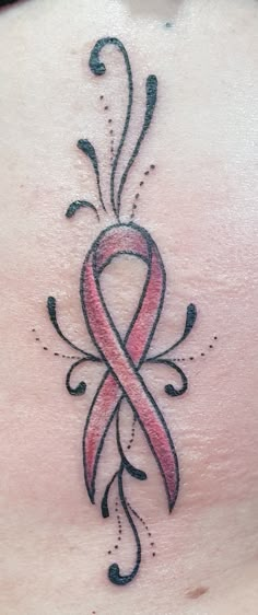 a pink ribbon tattoo on the back of a woman's stomach with swirls