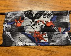 two spiderman face masks on a wooden table