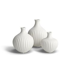 three white vases sitting next to each other