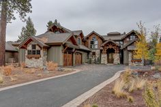 a large house with lots of windows on the front and side of it, surrounded by trees