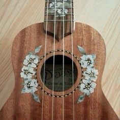 an ukulele is decorated with flowers and leaves