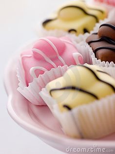 there are many different types of chocolates on the plate, one is white and pink