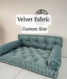 a blue couch with the words velvet fabric custom size on it and an image of a clock in the background