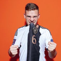 a man is holding his tie in front of his face