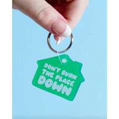 a person holding a keychain that says don't burn the place down