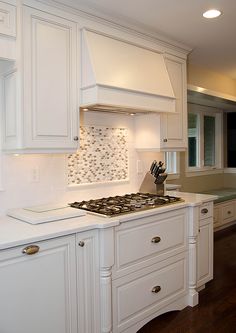 a kitchen with white cabinets and an oven