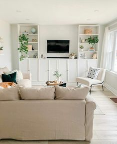 a living room filled with furniture and a flat screen tv mounted on the wall above it