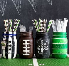 four mason jars with football game day straws in them