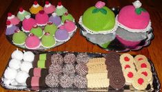 two trays filled with cakes and cupcakes on top of a wooden table