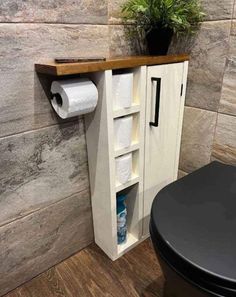 a toilet paper dispenser next to a wooden shelf