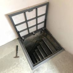 an open metal box on the ground with steps leading up to it's bottom