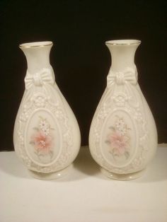 two white vases with pink flowers on them