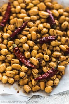 roasted chickpeas with chili peppers in a white bowl on top of parchment paper