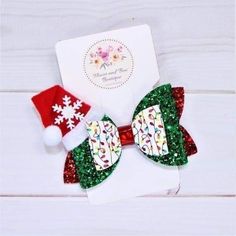 a bow with sequins and christmas hats on it sitting next to a card