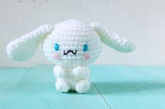 a white crocheted stuffed animal sitting on top of a blue table