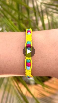 a person wearing a yellow bracelet with colorful beads