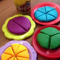 four different colored cookies sitting on top of plates