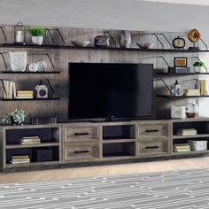 a large entertainment center with shelves and a flat screen tv on top of it in a living room