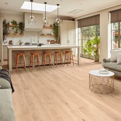 a living room filled with furniture next to a kitchen and an open floorplan