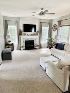 a living room with white furniture and a flat screen tv