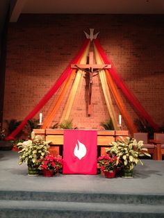 the altar is decorated with flowers, candles and a crucifix in the background