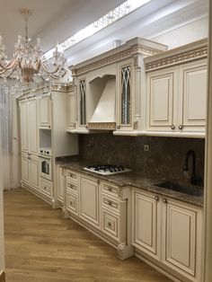 an empty kitchen with white cabinets and chandelier