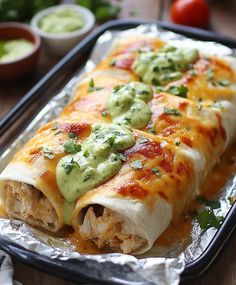 an enchilada is sitting in a pan on a table with salsa and guacamole