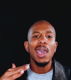 a close up of a person wearing a leather jacket and holding his hand out to the side