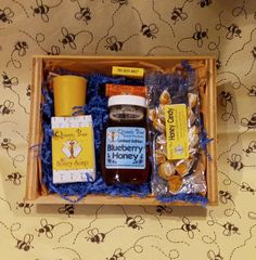 "Our  Popular Blueberry Beehive gift basket is a great gift for any occasion, birthday, appreciation gift, wedding gift, father's day or Christmas!  Our Blueberry honey is made by bees who are collecting the pollen and nectar from blueberry blossoms.  Absolutely delicious!  This basket now has blue crinkle paper, and comes with an 8 ounce jar of blueberry honey, a beeswax votive candle, a book of our Queen bee matches, our signature honey soap, a bag of honey candies, and a beeswax lip balm of y Bumble Bee Gift Basket, Honey Gift Basket Ideas, Honey Gift Box Ideas, Honey Gift Basket Favors, Bee Honey Gift Basket, Beeswax Lip Balm, Honey Bee Hives, Rosemary Mint, Honey Soap