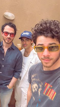 three men standing next to each other wearing sunglasses