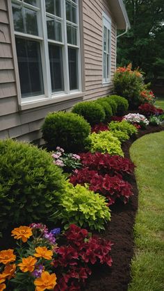 the flowers are blooming along the side of the house and in the front yard