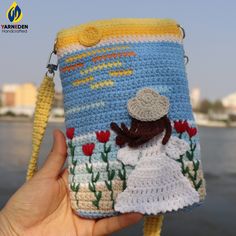 a crocheted purse with a woman in a white dress and hat on it