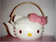 a hello kitty teapot with a pink bow on it's head and handle