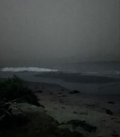 a foggy beach with the ocean in the distance