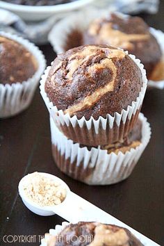 chocolate muffins with peanut butter frosting in white paper cups on a black surface