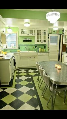 a kitchen with green walls and black and white checkered flooring on the floor