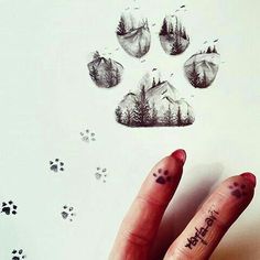 a person's hand with a tattoo on it and four paw prints in the background