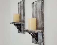 two candle holders are on the wall next to each other