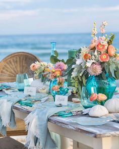 the table is set with flowers and place cards