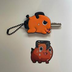 an orange and black animal shaped keychain sitting next to a small brown bear