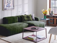 a living room filled with furniture and a painting hanging on the wall above it's windows