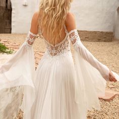 the back of a woman's white wedding dress, with long sleeves and open shoulders