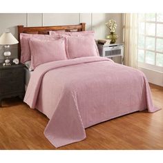 a bed with pink bedspread and pillows