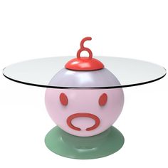 a glass table with a pig face on it and a red object in the middle