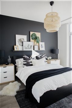 a black and white bedroom with pictures on the wall