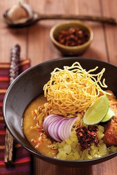 a bowl filled with noodles, meat and vegetables