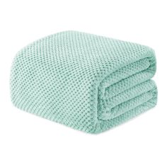 the aqua green blanket is folded on top of it's white surface and has two rows