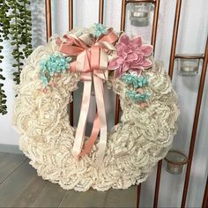 a white wreath with pink and blue flowers on it